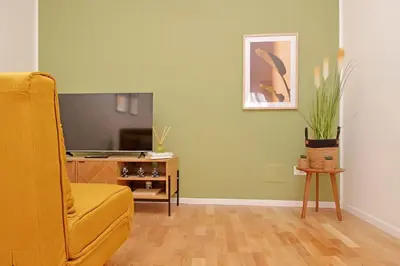 a living room with a yellow couch and a television at Nature Flat in Rome