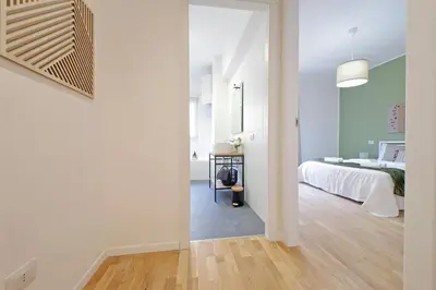 a white bedroom with a bed and a table at Nature Flat in Rome