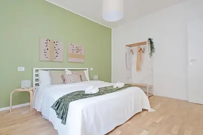 a bedroom with a white bed and a green wall at Nature Flat in Rome