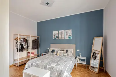 a bedroom with a bed and a blue wall at Gardenie House in Rome