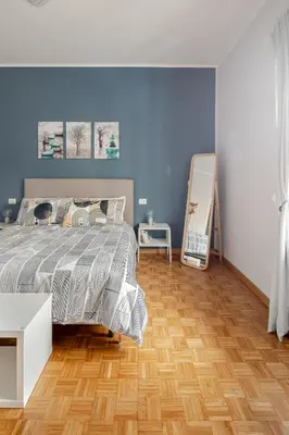 a bedroom with a bed and a wooden floor at Gardenie House in Rome
