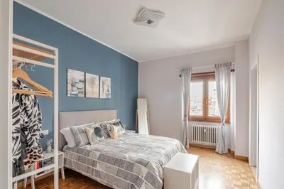 a bedroom with a bed and a blue wall at Gardenie House in Rome