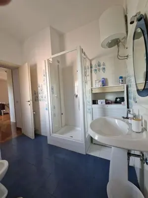 a white bathroom with a shower and a sink at casa a PortaPortese in Rome