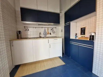 a kitchen with blue and white cabinets and blue tiles at casa a PortaPortese in Rome