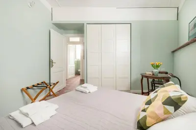 a bedroom with a white bed and a table at Iside Apt at Colosseum -2 bedrooms 2 bathrooms in Rome