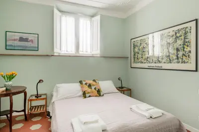 a small bedroom with a bed and a table at Iside Apt at Colosseum -2 bedrooms 2 bathrooms in Rome