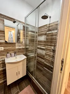 a bathroom with a glass shower and a sink at Casa Dà! in Rome