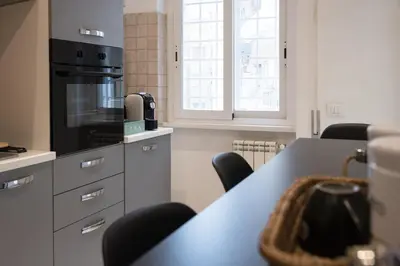 a kitchen with a table with chairs and a stove at Casa Eva - Roma in Rome