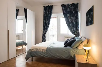 a bedroom with a bed and a large window at Casa Eva - Roma in Rome
