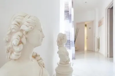 a white statue of a woman in a hallway at Veneto Excelsior Suite in Rome