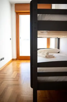 two bunk beds in a room with a door at Aurelia Vatican City Apartment in Rome