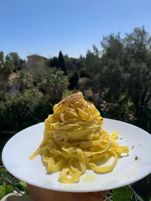 a person holding a plate with pasta on it at Aurelia Vatican City Apartment in Rome