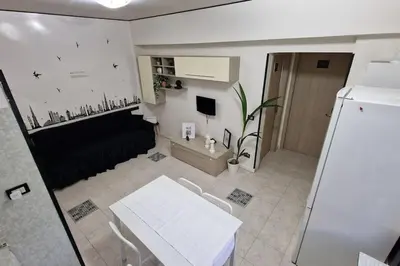 a small room with a white table and a refrigerator at Brik's House in Rome