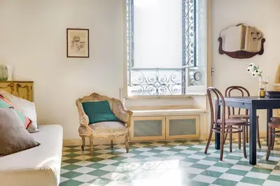 a living room with a table and chairs and a window at Volturno's Unique View in Rome