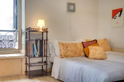 a room with a bed and a lamp and a window at Volturno's Unique View in Rome