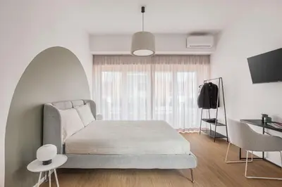 a white bedroom with a bed and a window at 4BNB - Suites del Gallo in Rome