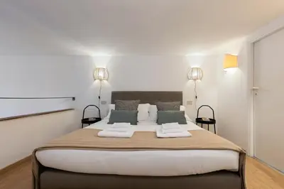 a bedroom with a large bed with two pillows at Rome As You Feel - Designer two-level apartment in the heart of Trastevere in Rome