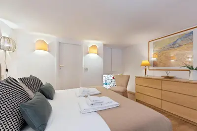 a bedroom with a white bed and a dresser at Rome As You Feel - Designer two-level apartment in the heart of Trastevere in Rome
