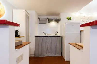 a kitchen with a sink and a refrigerator at Rome As You Feel - Designer two-level apartment in the heart of Trastevere in Rome