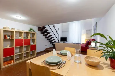 a dining room with a table and a living room at Rome As You Feel - Designer two-level apartment in the heart of Trastevere in Rome