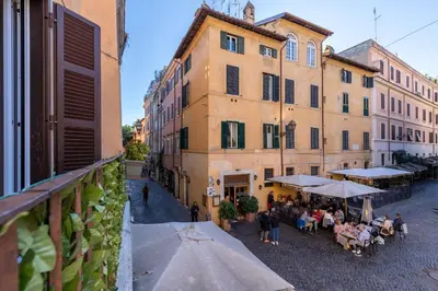a group of people sitting at tables outside a building at Rome As You Feel - Designer two-level apartment in the heart of Trastevere in Rome