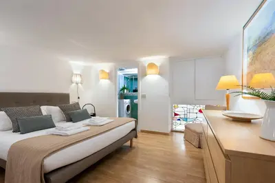 a bedroom with a large bed and a kitchen at Rome As You Feel - Designer two-level apartment in the heart of Trastevere in Rome