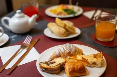 a table with plates of bread and toast and orange juice at BH Hotel in Rome