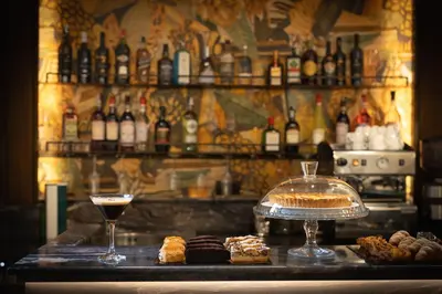 a table with a cake and a drink and some pastries at BH Hotel in Rome