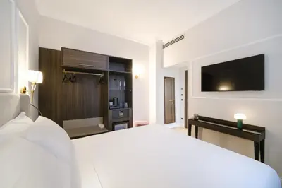 a hotel room with a bed and a flat screen tv at BH Hotel in Rome