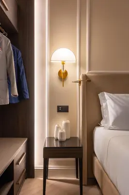 a bedroom with a bed and a table with a lamp at BH Hotel in Rome