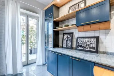 a kitchen with blue cabinets and a wall of windows at La Casa di Cesare in Rome