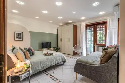 a bedroom with a bed and a couch and a tv at La Casa di Cesare in Rome