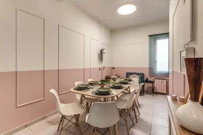 a dining room with a table and white chairs at La Casa di Cesare in Rome