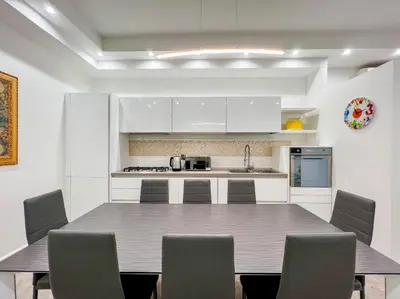 a kitchen with white cabinets and a table and chairs at LA CORTE at the Colosseum in Rome