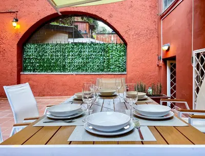 a table with plates and wine glasses on a patio at LA CORTE at the Colosseum in Rome