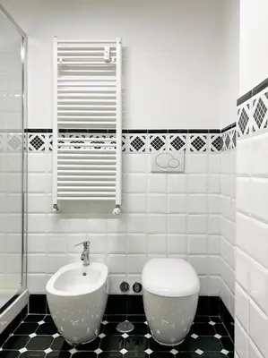 a white bathroom with a sink and a toilet at LA CORTE at the Colosseum in Rome