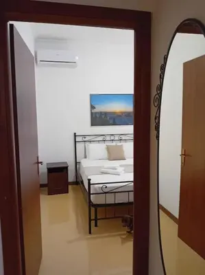 a mirror reflecting a bedroom with a bed in a room at Vatican Home Borgo Pio II in Rome