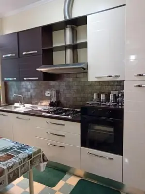 a kitchen with white cabinets and a black stove top oven at Vatican Home Borgo Pio II in Rome
