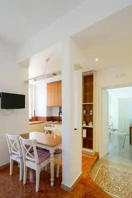 a kitchen and dining room with a table and chairs at Sognando Vacanze Romane in Rome