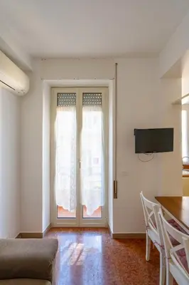 a living room with a couch and a television on the wall at Sognando Vacanze Romane in Rome