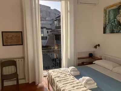 a bedroom with a bed and a large window at Your nest at Colosseum!! in Rome