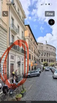 a city street with buildings and people sitting at tables at Your nest at Colosseum!! in Rome