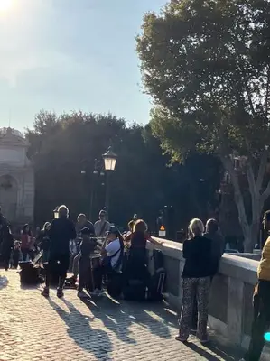 a group of people standing around a stone wall at Amazing Terrace in Trastevere in Rome
