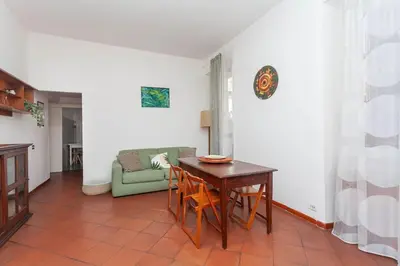 a living room with a table and a green couch at Cami Vatican Apartment in Rome