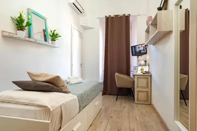 a small bedroom with a bed and a desk at Central Rooms - Vatican in Rome