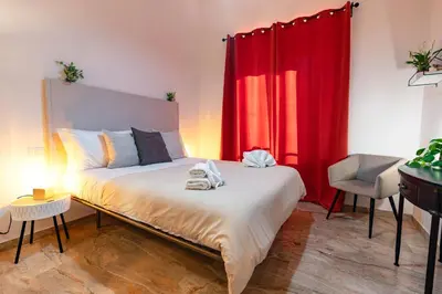 a bedroom with a bed with a red curtain at Central Rooms - Vatican in Rome