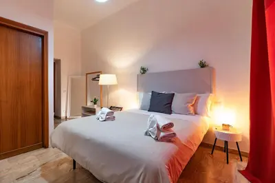 a bedroom with a large white bed with two pillows at Central Rooms - Vatican in Rome