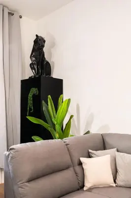 a living room with a couch and a plant at Dimora Colosseum Luxe - Jacuzzi & Private Patio in Rome
