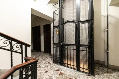 an iron gate in a hallway with a staircase at Dimora Colosseum Luxe - Jacuzzi & Private Patio in Rome