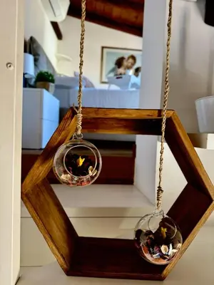 two glass bowls hanging from a wooden frame at Pantheon Gabbianina Home in Rome